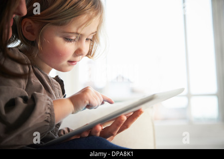 Madre e figlia con tavoletta digitale Foto Stock