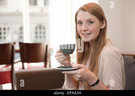 Ritratto di giovane donna di bere il caffè nella caffetteria Foto Stock
