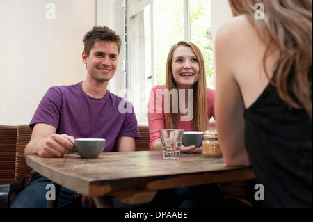 Gruppo di amici in chat in cafe Foto Stock