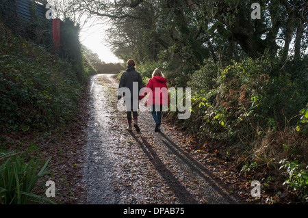 Una madre e figlia a piedi lungo una corsia in Cornwall, Regno Unito Foto Stock