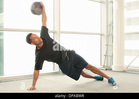 L uomo lo stiramento usando palla ginnica Foto Stock