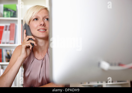 Metà donna adulta sul telefono di rete fissa Foto Stock