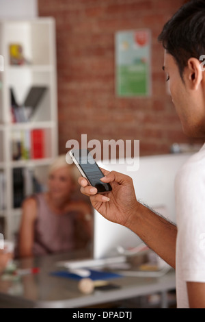 Giovane uomo utilizza lo smartphone Foto Stock