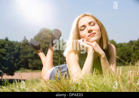 Giovane donna godendo il sole in posizione di parcheggio Foto Stock