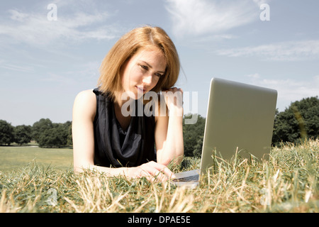 Giovane donna utilizzando laptop in posizione di parcheggio Foto Stock