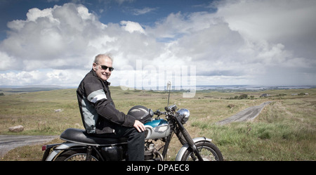 Maschio Senior motociclista prendendo una pausa Foto Stock