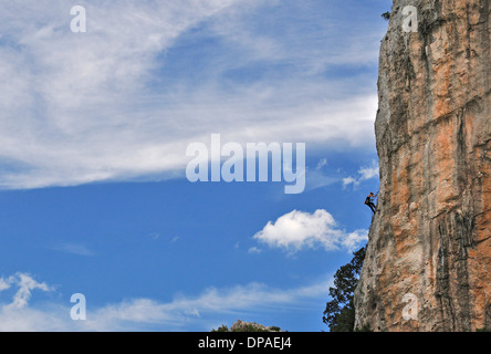 Free climber ragazza si arrampica sulle rocce di Cala Luna, Cala Gonone, Dorgali, Sardegna, Italia, uno dei migliori spot per arrampicata. Foto Stock