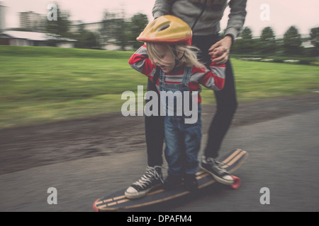 Madre e figlia a cavallo su skateboard in posizione di parcheggio Foto Stock