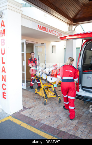 I paramedici spostamento del paziente attraverso la porta dell'ospedale Foto Stock