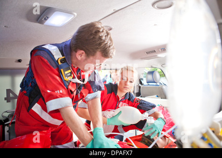 I paramedici dando paziente massaggio cardiaco in ambulanza Foto Stock