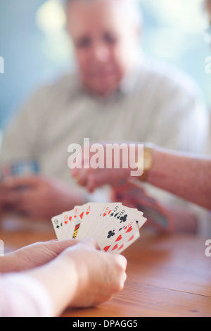 Maschio Senior giocando a carte con la famiglia Foto Stock