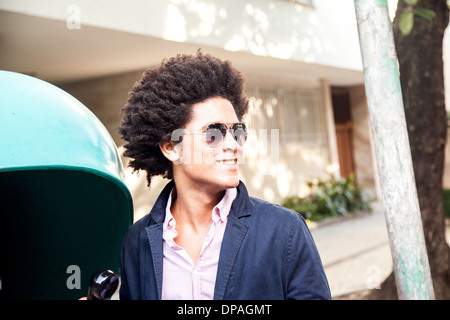 Giovane uomo in occhiali da sole da pagare telefono Foto Stock