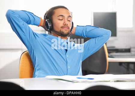 Giovane uomo che indossa le cuffie Foto Stock