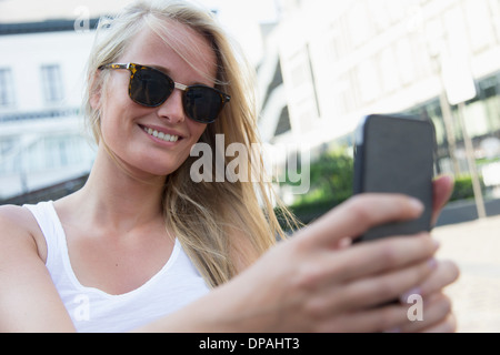 Giovane donna tramite telefono cellulare Foto Stock