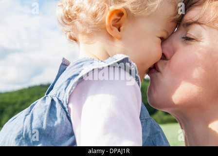 Madre baciare la figlia Foto Stock