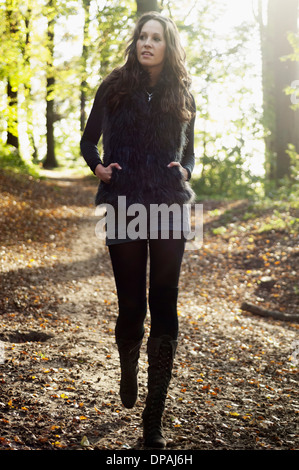 Ritratto di giovane donna che cammina nel bosco in autunno Foto Stock