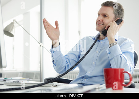 Imprenditore maturo sul telefono di rete fissa Foto Stock