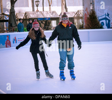 Hardy i visitatori si divertono pattinaggio sul ghiaccio in Bryant Park di New York Martedì, 7 gennaio 2014 come "vortice polare arriva Foto Stock