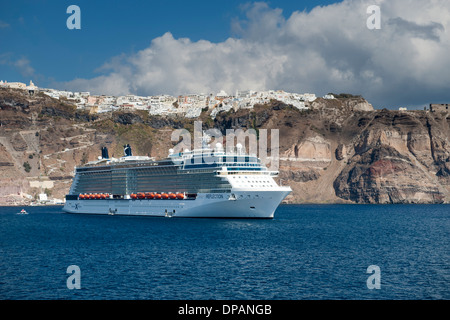 Vista del villaggio di Fira e una nave da crociera ancorata al largo dell'isola greca di Santorini. Foto Stock