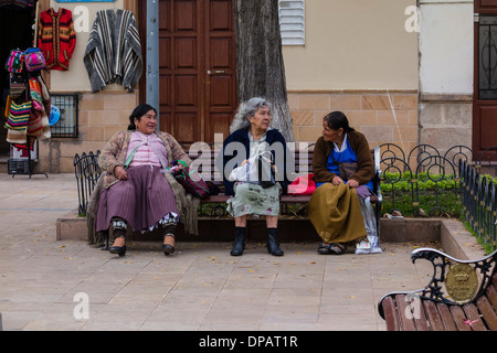 Tre Vecchi donna boliviana a sedersi su una panchina nel parco e parlare in Sucre, Bolivia. Foto Stock