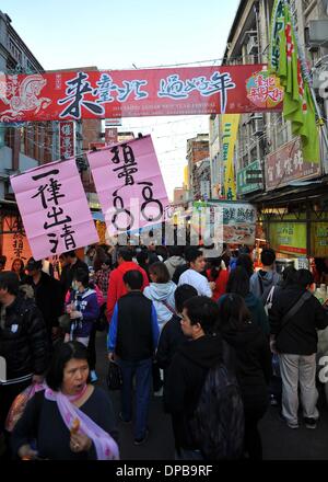 Taipei, Taiwan. Xi gen, 2014. Persone selezionare generi di prima necessità per la imminente nuovo anno lunare cinese a Dihua Street in Taipei, a sud-est di Taiwan, 11 genn. 2014. Dihua Street a residenti di Taipei gregge due settimane prima del nuovo anno lunare cinese è una grande destinazione per acquistare la speciale gli acquisti per la vacanza. Credito: Chen Yehua/Xinhua/Alamy Live News Foto Stock