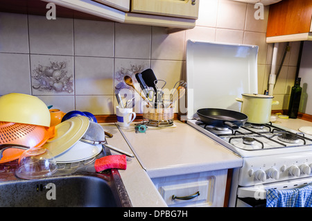 Vista di una cucina con piatti di essiccazione, piatti e tazze e vari utensili da cucina Foto Stock