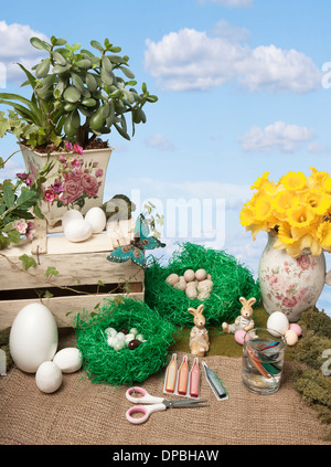 Pasqua arti e mestieri, con differenti uova di pasqua e conigli pasquali, su sfondo blu cielo Foto Stock