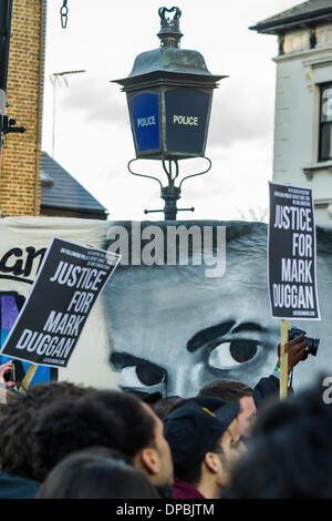 Londra, Regno Unito. 11 gennaio 2014. I sostenitori di Mark Duggan la famiglia tenere una veglia al di fuori di Tottenham stazione di polizia. Essi si sono radunati accanto a membri della famiglia e sua madre Pam Duggan, a 2pm a seguito di un' inchiesta giuria pregiudiziale che Duggan è stato legittimamente uccisa quando la polizia ha sparato lui morti mentre lui era disarmato. A pochi giorni dalla sua ripresa, nel 2011, disordini scoppiati nelle strade di Londra e diffondersi ad altre aree urbane in Inghilterra. Credito: Guy Bell/Alamy Live News Foto Stock