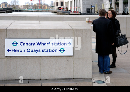 Londra, Inghilterra, Regno Unito. Docklands / Canary Wharf. Segno di dare le indicazioni per la stazione della metropolitana e Heron Quays Foto Stock