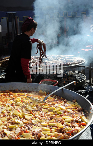 Padella grande con spezzatino di patate nella parte anteriore del gigante barbecue in annuale di tutti i Santi nel mercato Cocentaina, Spagna Foto Stock