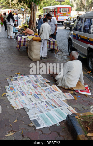 Un uomo a vendere giornali a Bombay in India Foto Stock