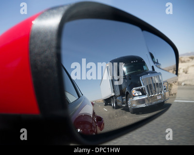 Un grande camion americani visto nell'ala specchio di una automobile Foto Stock