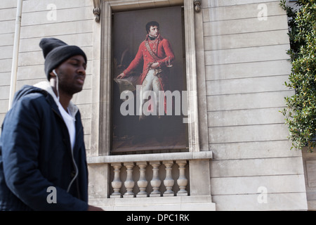 Parigi. La Francia. Un giovane cammina davanti al Museo Nazionale 'de la Légion d'honneur', sotto un'immagine di Napoleone. Foto Stock