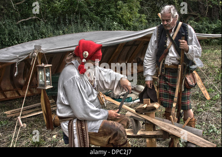 Il francese Voyageurs camp di canoa nei boschi con un voyageur la rasatura una racchetta Foto Stock