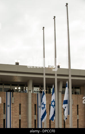 Gerusalemme. Xii gen, 2014. Israeliano bandiere nazionali sono a metà il montante per ex Primo Ministro israeliano Ariel Sharon all'ingresso quadrato della Knesset (parlamento) a Gerusalemme, a gennaio 12, 2014. Ex primo ministro Israeliano Ariel Sharon, una figura discutibile che ha cambiato il corso del Medio Oriente, è morto in un ospedale vicino a Tel Aviv in Israele centrale all'età di 85. Credito: Li Rui/Xinhua/Alamy Live News Foto Stock