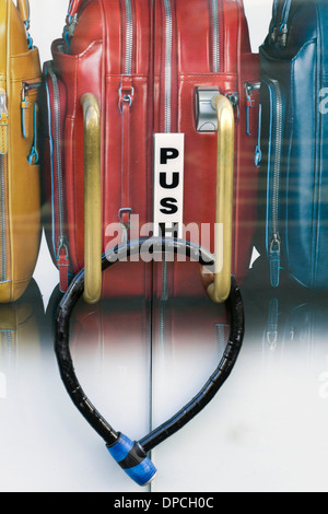 Designer bagagli dietro una bici incatenata bloccato lo sportello in vetro con Push scritta su di essi Foto Stock
