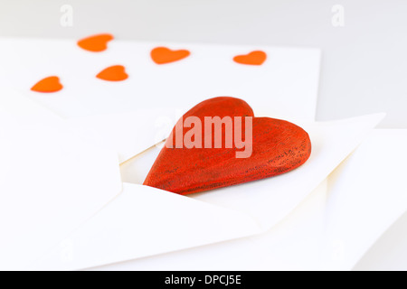 Rosso Cuore di legno nella busta. Lettera d'amore Foto Stock