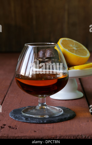 Bicchiere di brandy di cioccolato su un tavolo di legno Foto Stock
