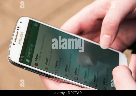 Ragazza utilizzando il Snapchat app su un Samsung Galaxy S4 telefono cellulare Android Foto Stock