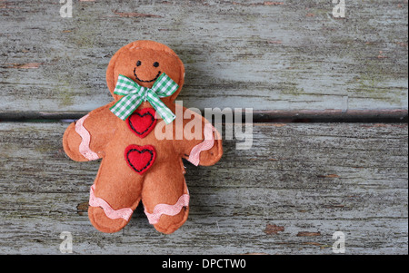 Sorridente gingerbread man posa su shabby chic panca in legno Foto Stock