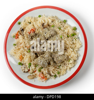 Cremosa di agnello korma curry guarnito con semi di sesamo tostati e servite su un letto di verdure, Pilaf dal di sopra Foto Stock