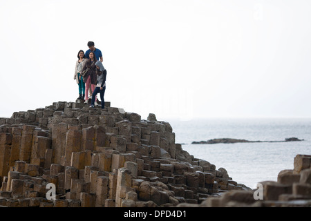 I visitatori a piedi e salire su pile di colonne di basalto che compongono la famosa in tutto il mondo Giants Causeway nella contea di Antrim. Foto Stock