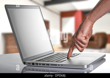 Computer portatile con man mano, il suo dito è premendo la barra spaziatrice Foto Stock