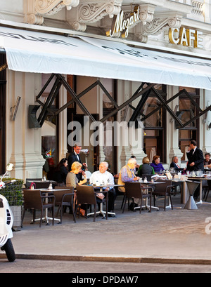 Alcune persone godono di una tazza di caffè presso la tradizionale caffetteria Viennese Mozart nella parte interna della città vicino all'Opera di Stato di Vienna Foto Stock