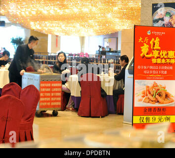 (140113) -- TAIYUAN, Gennaio 13, 2014 (Xinhua) -- cittadini cenare in un ristorante di Taiyuan, capitale del nord della Cina nella provincia dello Shanxi, 10 gennaio, 2014. Molti bei ristoranti di Taiyuan hanno cambiato il funzionamento tradizionale recentemente per soddisfare la media diners' domanda attraverso la modifica il suo menu di lusso in folk snack, remolding camere deluxe in comuni sala banchetti e fornendo group-acquistare pasti con prezzi bassi. Feng Shourui, un uomo in carica della cucina locale associazione in Shanxi, riteneva che solo seguendo la linea di massa potrebbe un ristorante di realizzare uno sviluppo sostenibile. (Xinhua/Yan Foto Stock