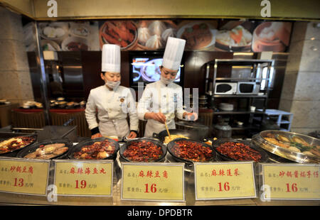 (140113) -- TAIYUAN, Gennaio 13, 2014 (Xinhua) -- chef preparano piatti ordinario in un raffinato ristorante di Taiyuan, capitale del nord della Cina nella provincia dello Shanxi, 10 gennaio, 2014. Molti bei ristoranti di Taiyuan hanno cambiato il funzionamento tradizionale recentemente per soddisfare la media diners' domanda attraverso la modifica il suo menu di lusso in folk snack, remolding camere deluxe in comuni sala banchetti e fornendo group-acquistare pasti con prezzi bassi. Feng Shourui, un uomo in carica della cucina locale associazione in Shanxi, riteneva che solo seguendo la linea di massa potrebbe un ristorante di realizzare uno sviluppo sostenibile svil Foto Stock