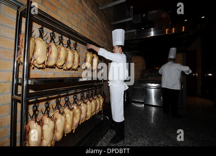 (140113) -- TAIYUAN, Gennaio 13, 2014 (Xinhua) -- uno chef arrosti anatre in un ristorante di Taiyuan, capitale del nord della Cina nella provincia dello Shanxi, Gennaio 6, 2014. Molti bei ristoranti di Taiyuan hanno cambiato il funzionamento tradizionale recentemente per soddisfare la media diners' domanda attraverso la modifica il suo menu di lusso in folk snack, remolding camere deluxe in comuni sala banchetti e fornendo group-acquistare pasti con prezzi bassi. Feng Shourui, un uomo in carica della cucina locale associazione in Shanxi, riteneva che solo seguendo la linea di massa potrebbe un ristorante di realizzare uno sviluppo sostenibile. (Xinhu Foto Stock