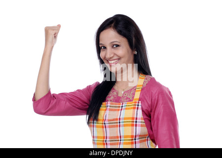 Felice giovane donna con grembiule da cucina contro white Foto Stock