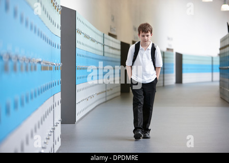 Scolaro infelice camminare da solo nel corridoio della scuola Foto Stock