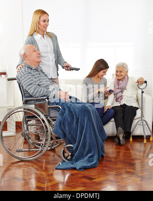 Il caregiver divertente dei cittadini anziani in una casa di riposo Foto Stock